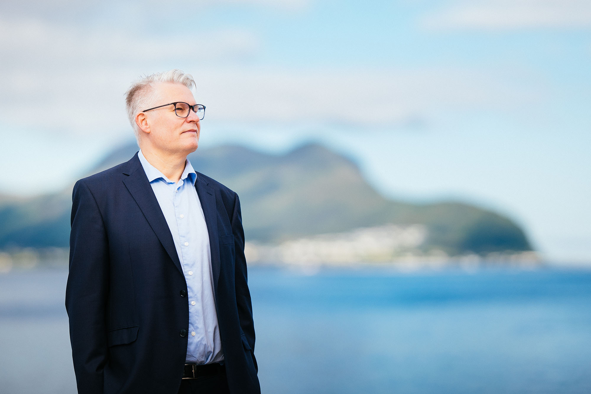 Forretningsmann med hav i bakgrunnen